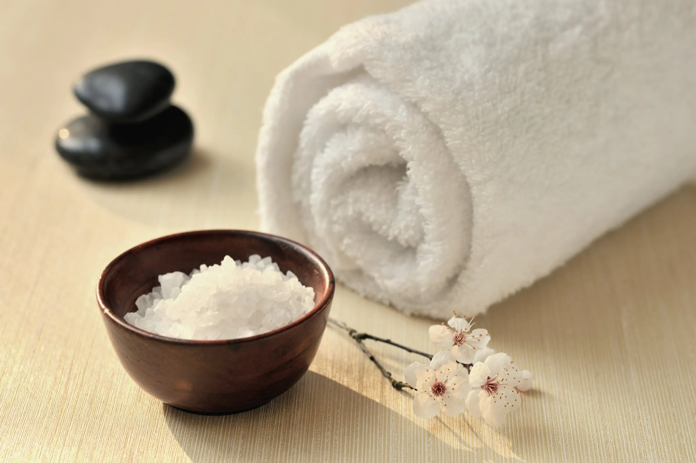 Rolled spa towel, sea salt and smooth stones at The Freeport House Spa